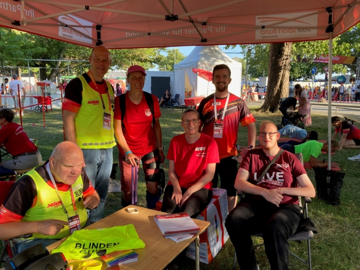Gruppe von Personen unter einem Sonnenschutzzelt